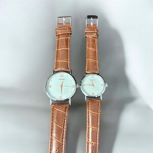 Brown leather-strap men’s and women’s watches with silver cases.